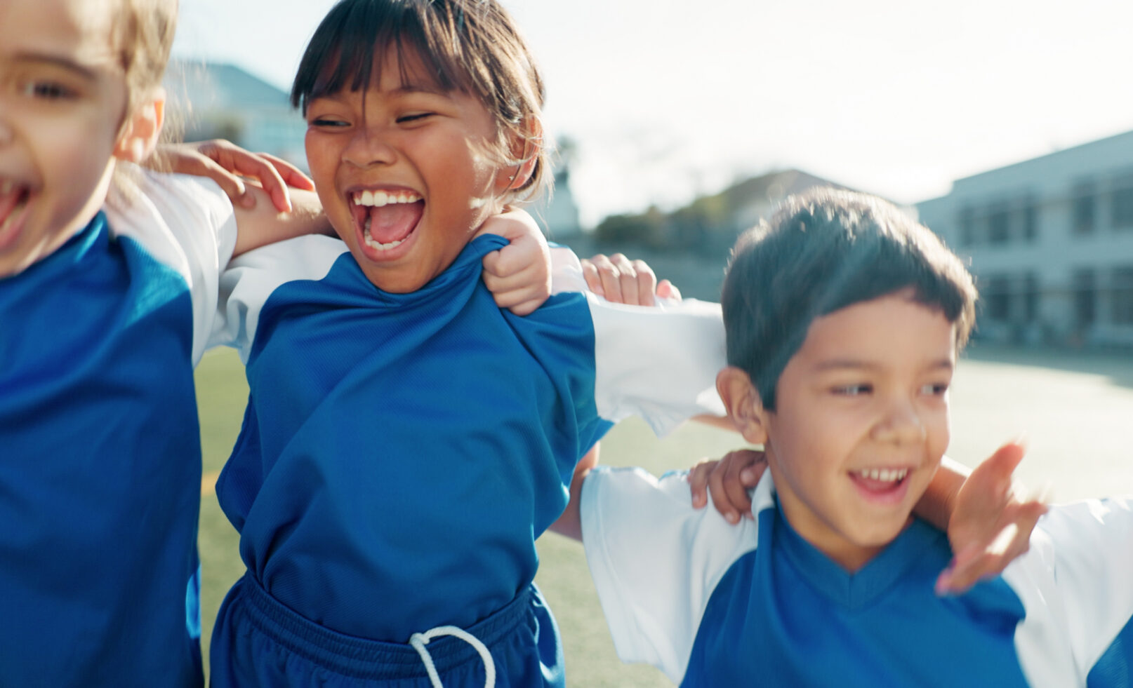Niños con camisetas azules celebran abrazados
